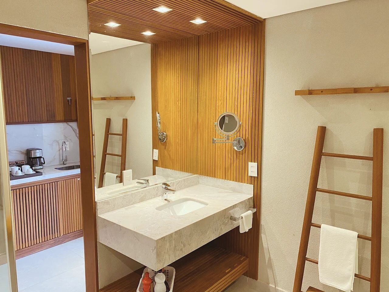 Un baño moderno con tocador de madera, un lavamanos grande y un espejo.