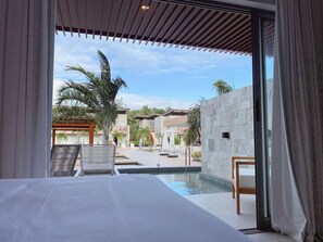 A hotel room with a view of a swimming pool, outdoor seating, and palm trees. - Flat Ilê de Pipa Lanai - By Almare (Tibau do Sul)