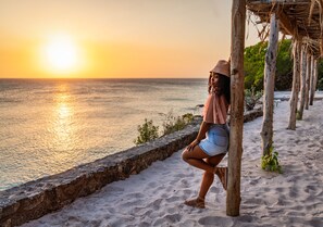 En la playa, playa de arena blanca y camas de playa (con cargo) 