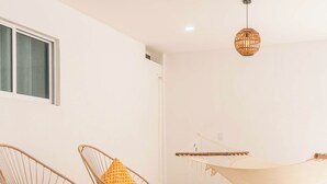 Ein modernes Interieur mit Rattanmöbeln, einer Hängematte und zwei Pendelleuchten.