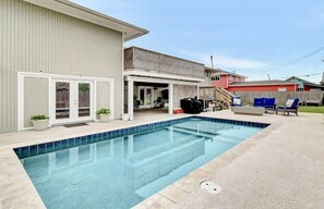 Une piscine privée, un patio couvert, un garage et une cour arrière clôturée.