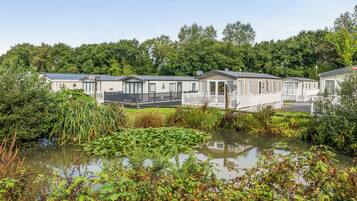 A row of mobile homes with a pond in the foreground.