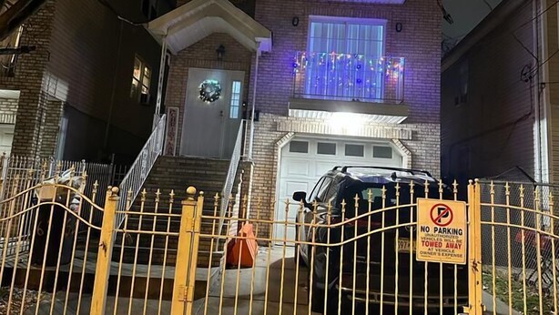 A two-story brick house with a garage, a gated driveway, and a 'No Parking' sign. - Glamour Room A Near EWR Aiport Penn Stat (Newark)