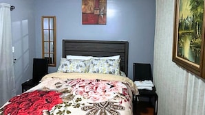A bedroom with a bed, a painting, a door, and a window. - Glamour Room A Near EWR Aiport Penn Stat (Newark)