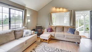 A spacious living room with a large window, a fireplace, and a cozy seating area. - Bay Area Escape on 5 Acres: Pet Friendly, Views (Greenwood)