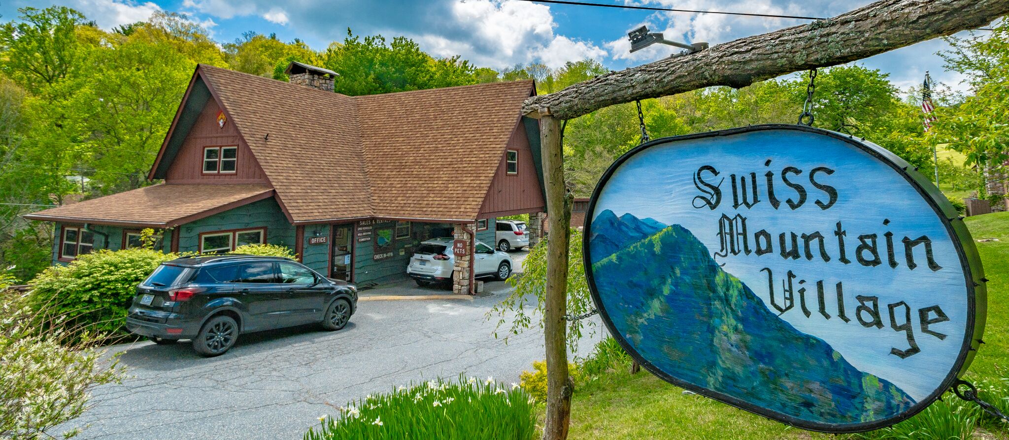 Un bâtiment avec un toit rouge et une enseigne sur laquelle on peut lire « Village de montagne suisse ».