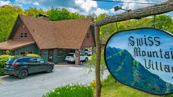 A building with a red roof and a sign that reads "Swiss Mountain Village".