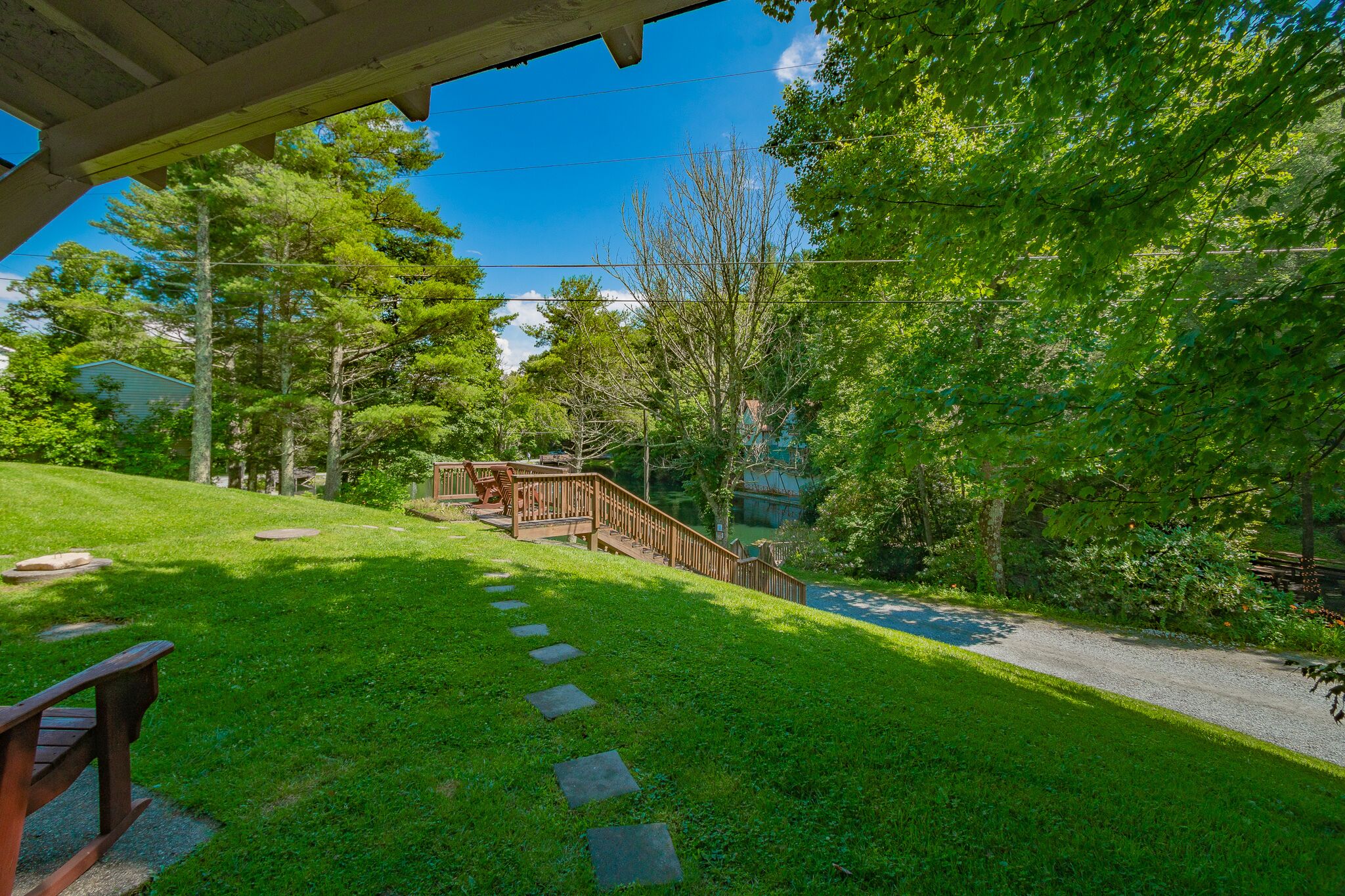 A grassy pathway leading to a wooden deck with a staircase.