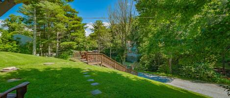 A grassy pathway leading to a wooden deck with a staircase.