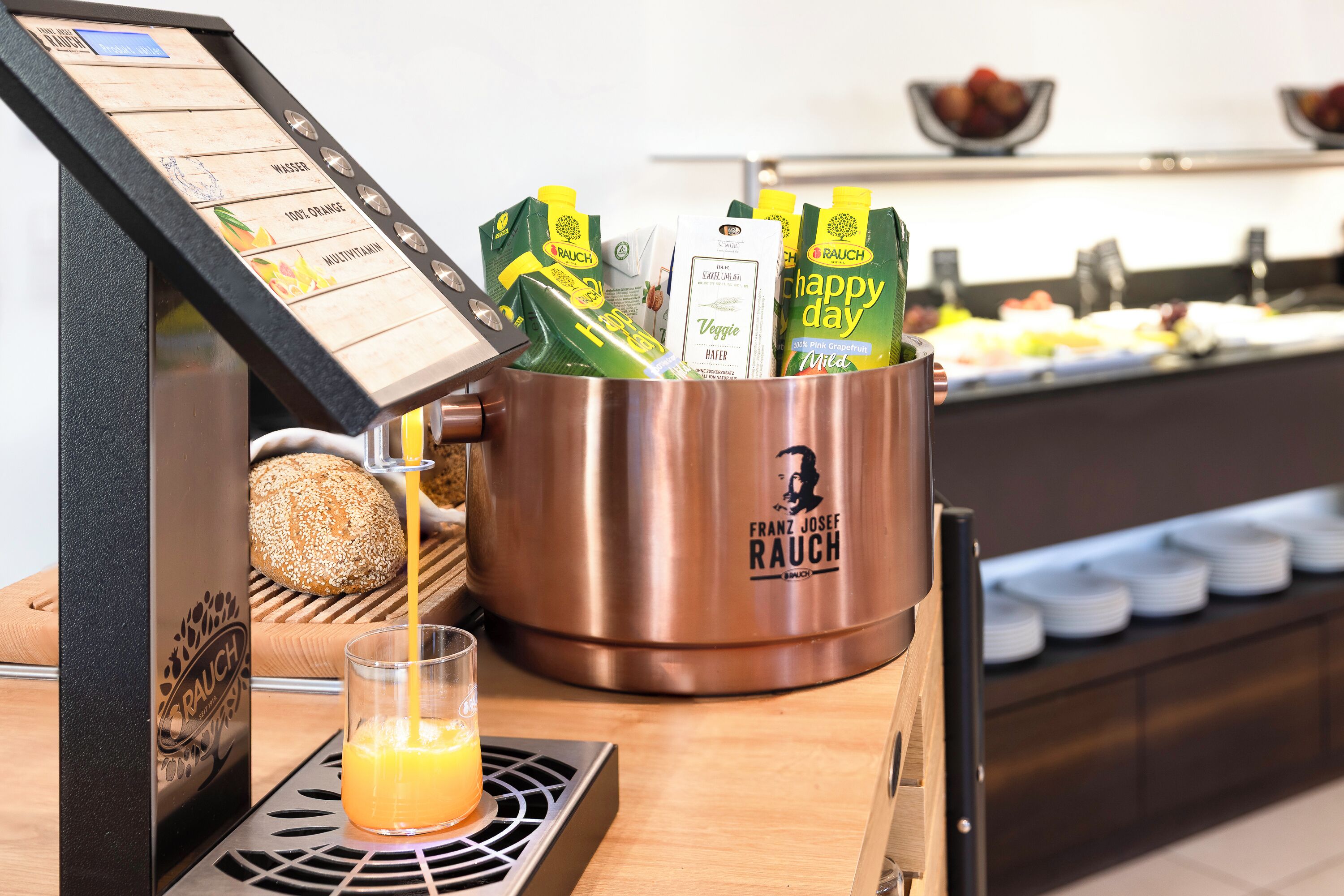 A coffee machine with a selection of coffee pods and a glass of orange juice.