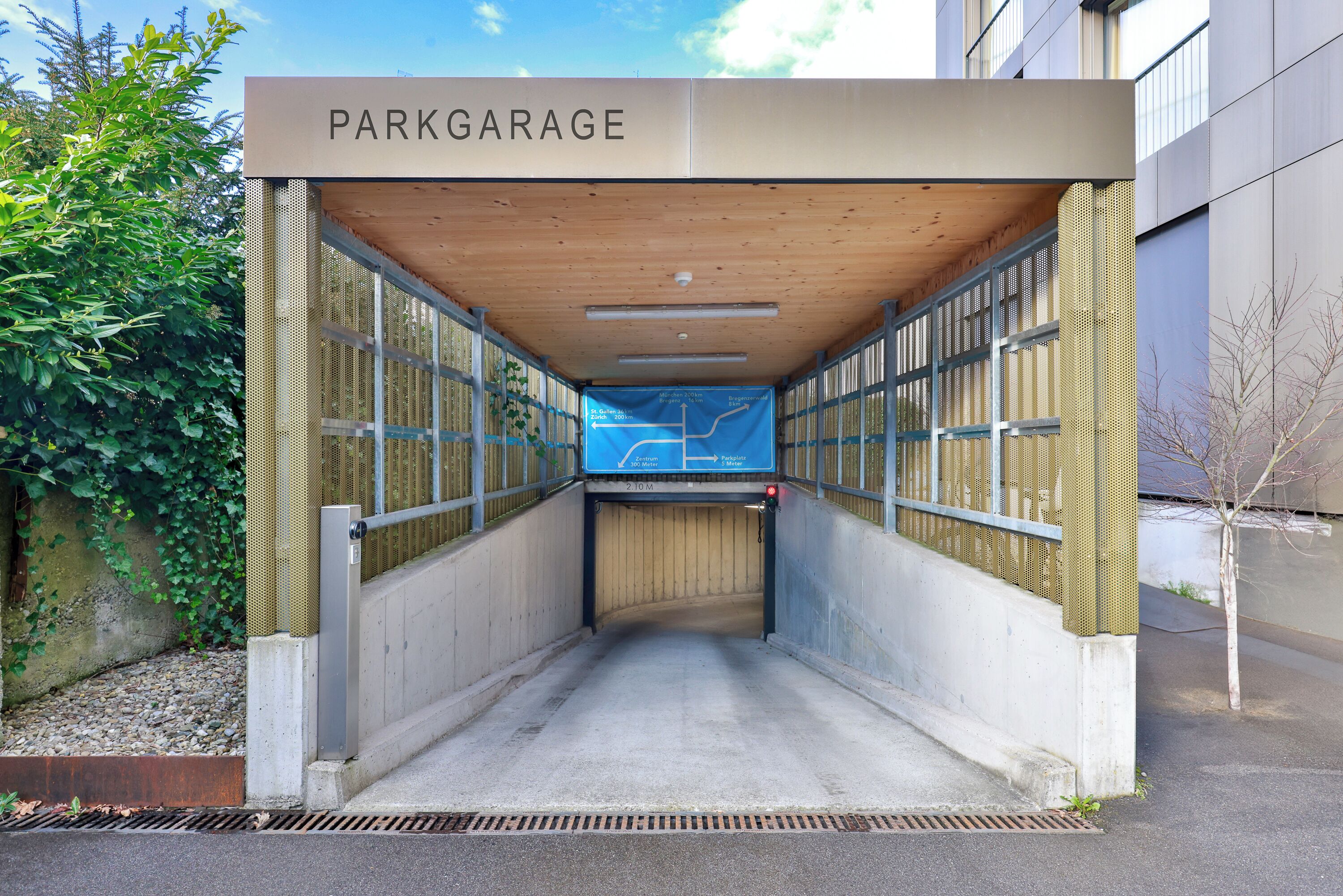 Entrada a un garaje cubierto para estacionamiento con un letrero que dice 'PARKGARAGE'.
