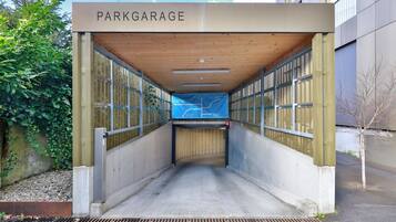 Entrada a un garaje cubierto para estacionamiento con un letrero que dice 'PARKGARAGE'.