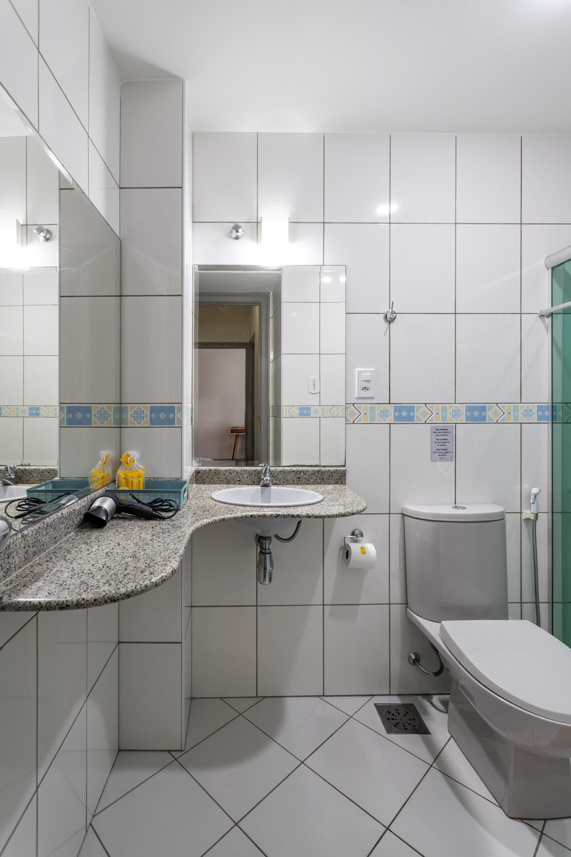 Ein Badezimmer mit Waschbecken, Spiegel, Toilette und Dusche.