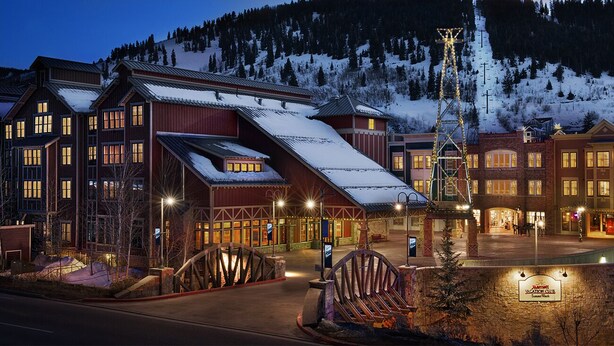Een chaletcomplex met meerdere gebouwen, een skilift en een bord waarop staat dat het een vakantieclub is.