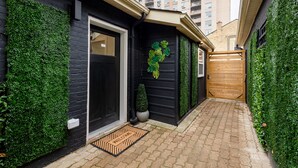 Une ruelle étroite avec une porte noire et un paillasson.