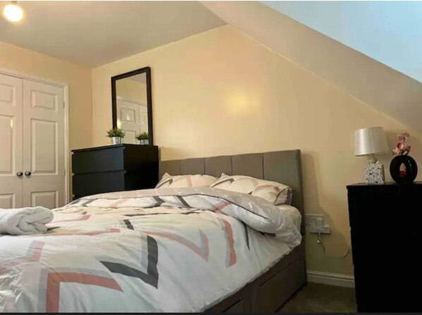 Cozy retreat with a neatly made bed and a simple, functional design.