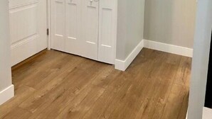 A room with a white wardrobe, wooden flooring, and light grey walls. - Modern Studio Apartment in Central West end, BJ Hospital (St. Louis)