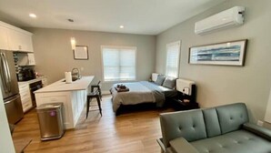 A compact living space with a kitchenette, a bed, a sofa, and a dining area. - Modern Studio Apartment in Central West end, BJ Hospital (St. Louis)