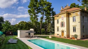 Un bâtiment à deux étages doté d’une piscine, d’un petit patio et d’une pelouse bien entretenue.