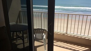 A balcony with a view of the ocean, a chair, and a table. - Oceanfront Getaway!! Relaxing Condo on the no-drive Beach
15% discount thru July (Ponce Inlet)