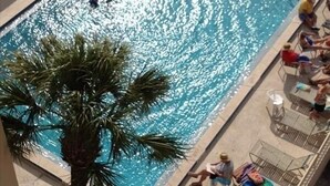 A rectangular pool with clear blue water, surrounded by lounge chairs and a palm tree. - Oceanfront Getaway!! Relaxing Condo on the no-drive Beach
15% discount thru July (Ponce Inlet)
