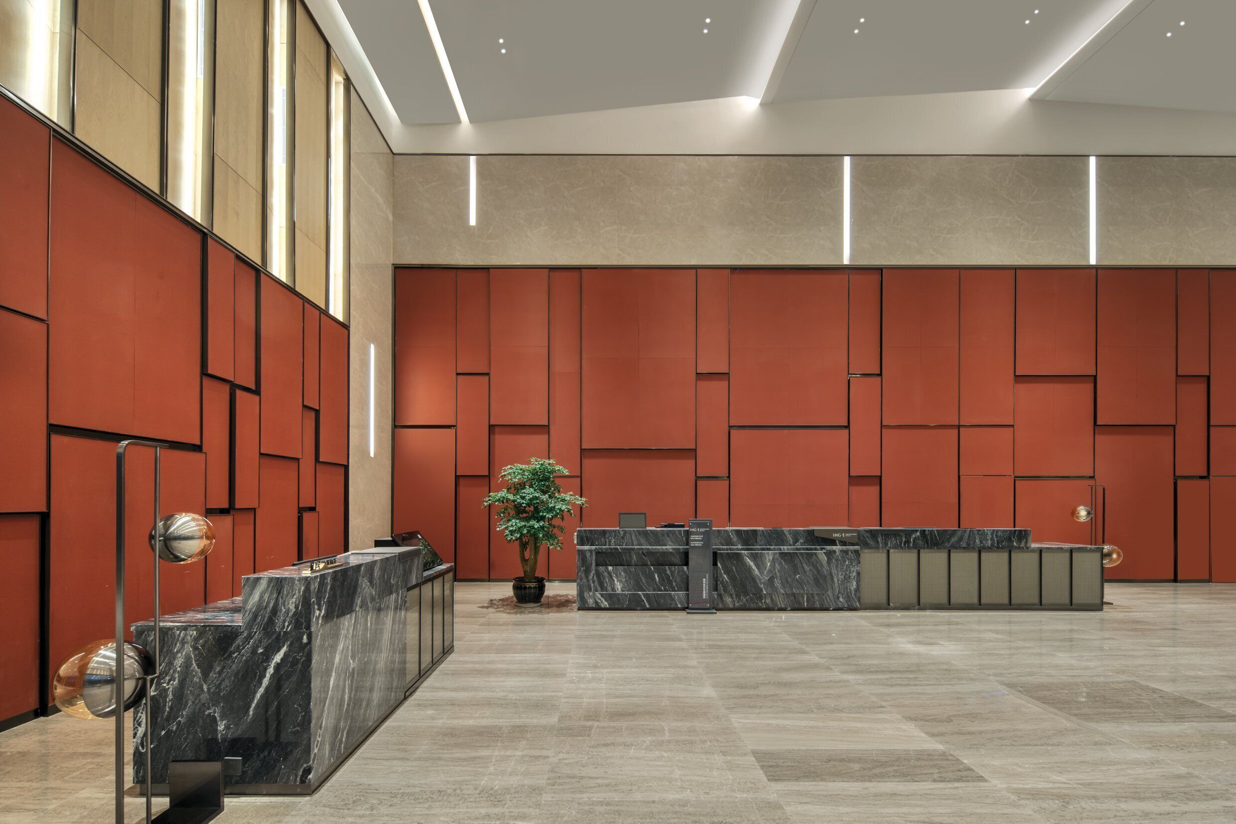 Un hall espacioso con mostrador de recepción, una planta en maceta y un diseño de techo moderno.