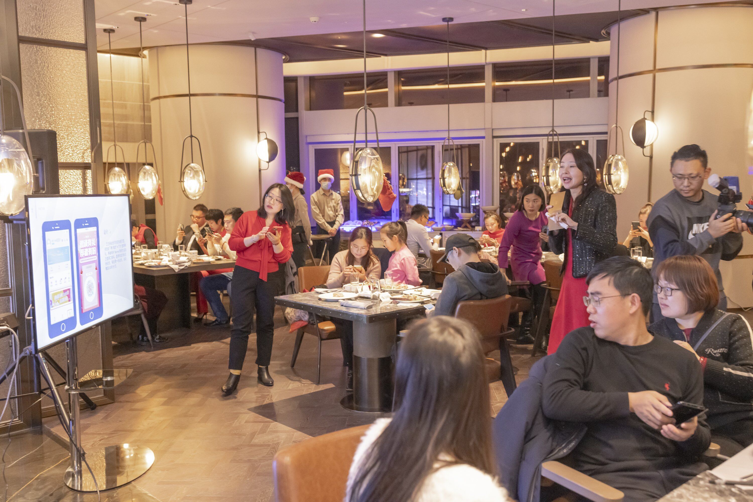 A restaurant with tables and chairs, a waiter, and diners.
