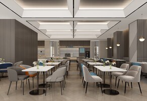Un comedor moderno con varias mesas y sillas, una barra central e iluminación colgante.