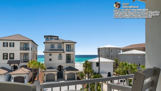 A beachfront hotel with multiple buildings, a balcony with a chair and a bowl of ice cream, and a clear view of the ocean. - Few steps across from beach, Gulf views, Saltwater pool, Golf cart (Miramar Beach)