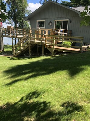 Ein Haus mit einer Holzterrasse und einer Treppe zu einem überdachten Bereich.