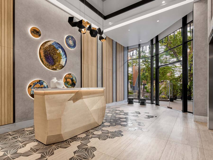 A modern reception area with a curved reception desk, geometric patterned floor, and decorative wall art.