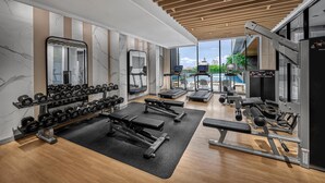 A modern gym with various exercise equipment, including dumbbells, treadmills, and weight machines. - Hyatt Place Makassar (Makassar)