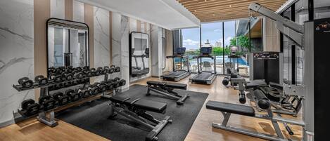 A modern gym with various exercise equipment, including dumbbells, treadmills, and weight machines.