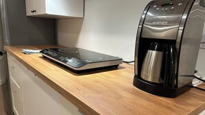 En köksbänk med en kaffebryggare och en digital våg.