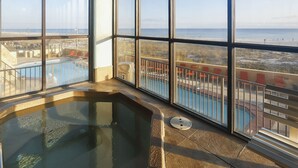 Un espace avec un jacuzzi offrant une vue sur la plage et la piscine.