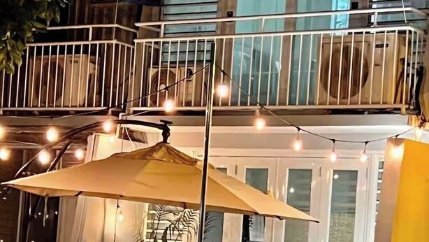 A balcony with a railing, chairs, and string lights. - Beach Villa in Dorado del Mar! Walk to the beach, restaurants, pool, casino (Dorado)