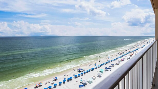 A beach with a long stretch of umbrellas and beach chairs, a clear sky, and the ocean. - GULF-FRONT CONDO, INDOOR/OUTDOOR POOL, BEACH ACCESS! (Gulf Shores)