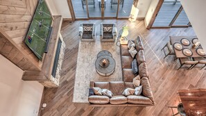 A spacious living area with a large sectional sofa, a coffee table, and a dining table set for six.
