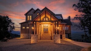 A large, two-story house with a prominent front porch and stone foundation.