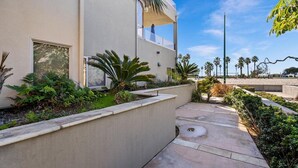A modern building with a balcony, a pathway, and a view of the beach. - Three Bedroom on the Ocean Front! (San Diego)