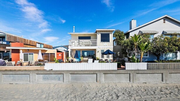 A beachfront property with multiple houses, a sandy beach, and a white fence. - Cute and cozy one-bedroom unit in South Mission (San Diego)