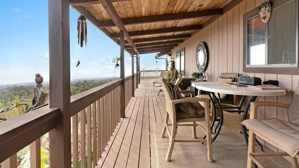 A wooden deck with wicker furniture and a view of the landscape. - No longer available for short term rental due to county restrictions (Captain Cook)