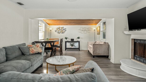 Un salon moderne avec un canapé gris, une table basse ronde et une cheminée.
