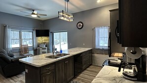 A modern kitchen with a marble countertop, dark cabinetry, and a built-in oven. - Big Chip - 1 is in the heart of the Chippewa Flowage 20 minutes from Hayward, WI (Hayward)