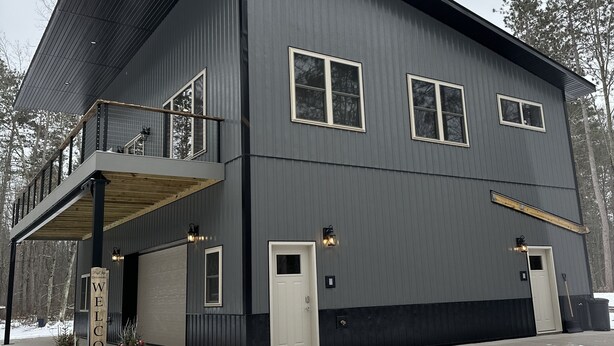 A large, modern building with a flat roof, multiple windows, and a covered entrance area. - Big Chip - 1 is in the heart of the Chippewa Flowage 20 minutes from Hayward, WI (Hayward)