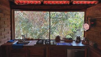A kitchen with a large window, wooden cabinets, and various kitchen appliances.