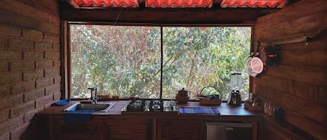 Une cuisine dotée d’une grande fenêtre, de meubles en bois et de divers appareils de cuisine.