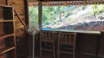 A wooden room with a fan, a table, and two chairs.