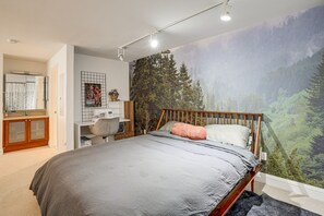 Relax in a serene bedroom with a large bed, wooden headboard, and wall-mounted desk.