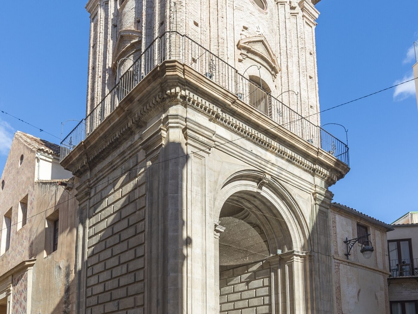 Un bâtiment historique en pierre, doté d’une tour imposante et d’une entrée en arc de cercle.